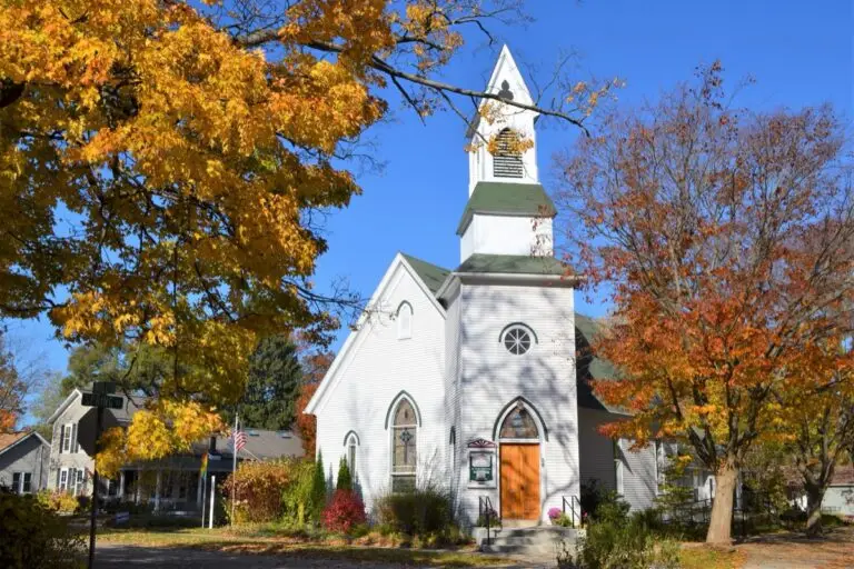 Church financing loan options - beautiful white church stands between trees